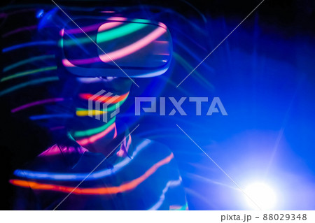 Young woman using virtual reality headset at dark interactive VR exhibition 88029348