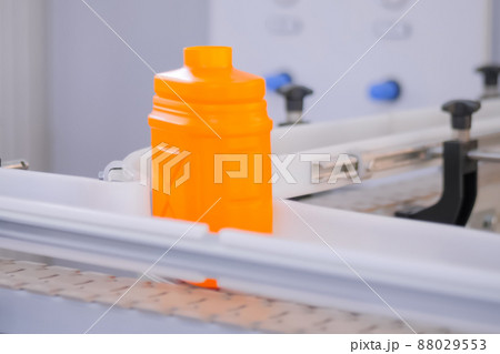 Empty orange plastic jerry can moving on conveyor belt at exhibition Empty orange plastic jerry can moving on conveyor belt at exhibition 88029553