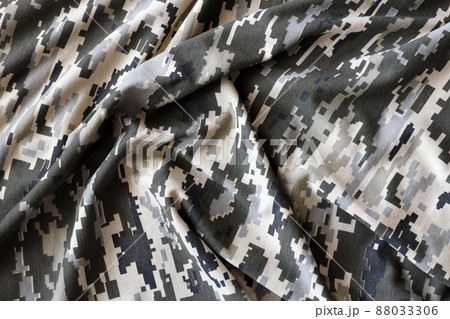 Fabric with texture of Ukrainian military pixeled camouflage. Cloth with camo pattern in grey, brown and green pixel shapes. Official uniform of Ukrainian soldiers 88033306