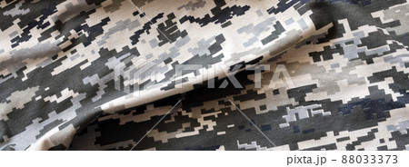 Fabric with texture of Ukrainian military pixeled camouflage. Cloth with camo pattern in grey, brown and green pixel shapes. Official uniform of Ukrainian soldiers 88033373