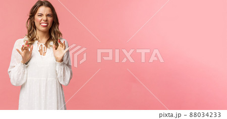 Portrait of girl cringe as telling friend disgusting awful story of her date with guy, show tongue grimacing and press hands to body as feeling discomfort and aversion, stand pink background 88034233