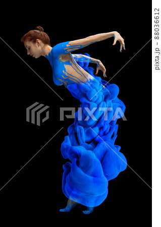 Portrait of young beautiful woman covered with black thick pain and dye splash dancing isolated over black background. Flexibility Portrait of young beautiful woman covered with black thick pain and dye splash dancing isolated over black background. Flexibility 88036612