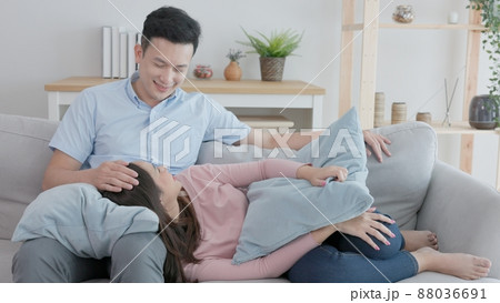 At home, a man and woman pair hug each other on the sofa, generous with their devotion. At home, a man and woman pair hug each other on the sofa, generous with their devotion. 88036691