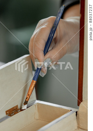 Women's gloved hands work with an artistic brush, repainting furniture 88037237