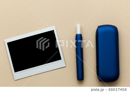 Iqos electronic blue cigarette on a beige background. Iqos electronic blue cigarette on a beige background. 88037408
