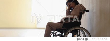Sad woman sitting in wheelchair in rehabilitation center Sad woman sitting in wheelchair in rehabilitation center 88038778