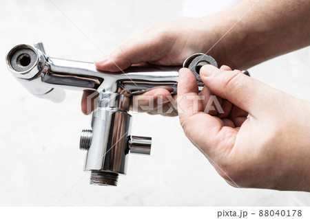 plumber installs paronite gasket in faucet closeup 88040178