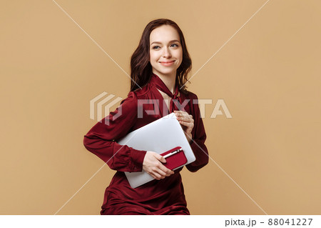 A woman holds a laptop and a phone in her hand 88041227