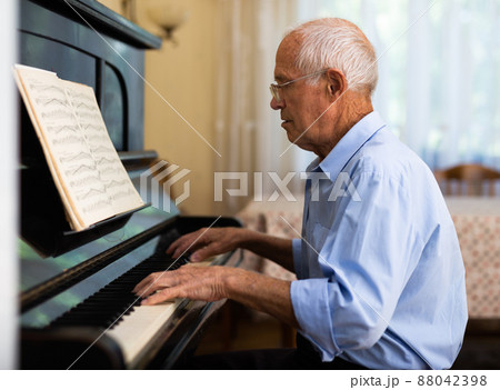 Senior man learning to play piano 88042398