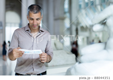 Man is looking at the exposition with brochure 88044351