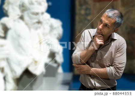 Adult man is visiting museum and looking at the exposition Adult man is visiting museum and looking at the exposition 88044353