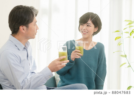 野菜ジュースを飲む父親と娘 88047683