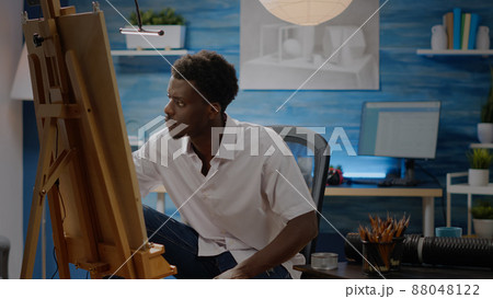 Artist of african american ethnicity working on drawing of vase at art studio. Black young adult using pencil and canvas on easel for creative masterpiece. Person with fine art project Artist of african american ethnicity working on drawing of vase at art studio. Black young adult using pencil and canvas on easel for creative masterpiece. Person with fine art project 88048122