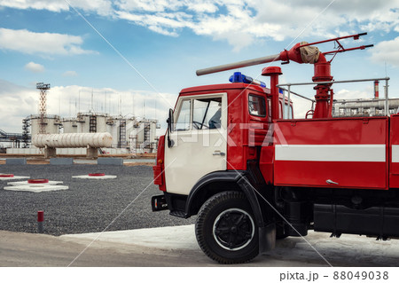A fire truck is on duty at an oil refinery 88049038