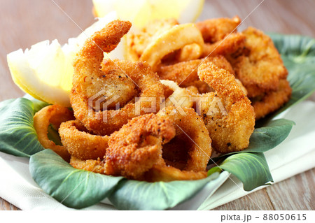 Fried squid rings breaded with lemon on a plate Fried squid rings breaded with lemon on a plate 88050615