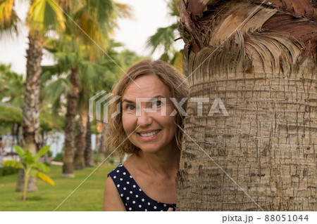 Portrait of a mature woman 50-60 years old against the backdrop of palm trees 88051044