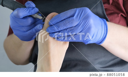 master makes a pedicure to a client in a beauty salon, using a professional apparatus for peeling 88051058