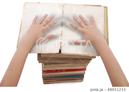 Hands above stacked old books of different shape and color. Hands above stacked old books of different shape and color. 88051233
