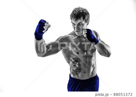 Studio shot of silhouette kickboxer who practicing uppercut on white background. Blue sportswear Studio shot of silhouette kickboxer who practicing uppercut on white background. Blue sportswear 88051372