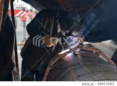 Jointing of large diameter pipes together. Welder performs the tack of stacked pipes 88053083