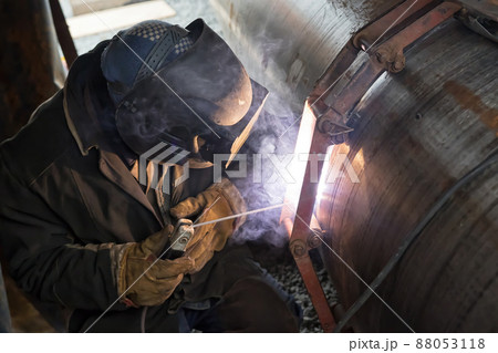 Jointing of large diameter pipes together. Welder performs the tack of stacked pipes Jointing of large diameter pipes together. Welder performs the tack of stacked pipes 88053118