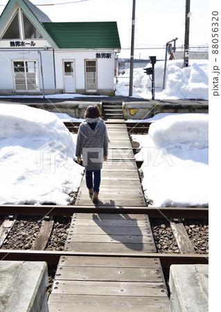 早春の北海道黒松内町で熱郛駅の横断歩道を歩く女性の居る風景を撮影 88056320