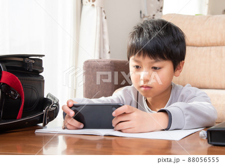 勉強中にスマホを見る小学生の男子 88056555