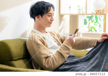 男性　スマホ　リビング　ソファ 88057212