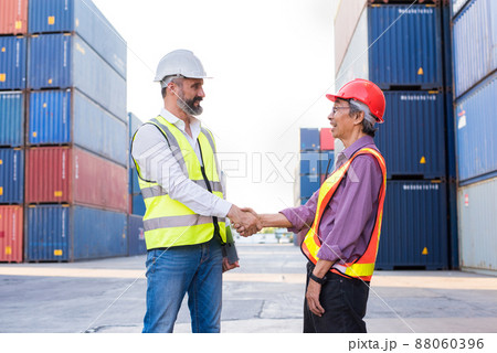 Foreman handshake engineer control loading Containers box from Cargo freight ship for import export. Freight containers in sea port. Foreman handshake engineer control loading Containers box from Cargo freight ship for import export. Freight containers in sea port. 88060396