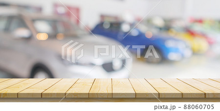 Empty wood table top with cars in showroom blurred defocused background 88060705
