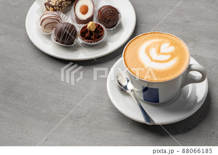 Coffee cup and sweet candy on gray table Coffee cup and sweet candy on gray table 88066185