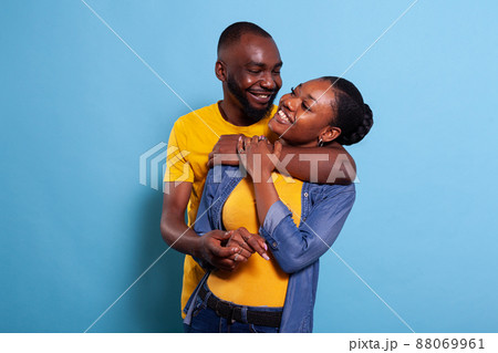 Joyful boyfriend hugging girlfriend and feeling happy together, showing love and gratitude. Cheerful people in relationship sharing romantic moment in studio. Couple embracing and smiling. Joyful boyfriend hugging girlfriend and feeling happy together, showing love and gratitude. Cheerful people in relationship sharing romantic moment in studio. Couple embracing and smiling. 88069961