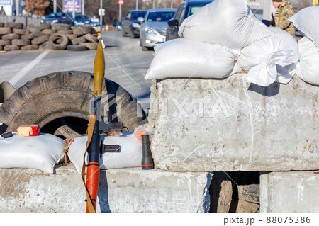 A hand grenade launcher at a checkpoint made of reinforced concrete blocks against the backdrop of a city street in Kyiv. 88075386