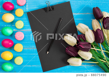 Easter eggs and tulips on blue wooden planks 88075490