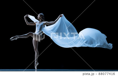 Graceful classic ballerina dancing with weightless fabric isolated on black studio background in neon. Theater, art, beauty, grace, action and motion concept. 88077416