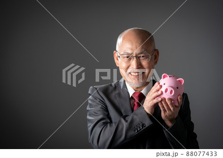 貯金箱を持つシニア男性 貯金箱を持つシニア男性 88077433