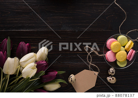 Easter eggs and tulips on dark wooden planks Easter eggs and tulips on dark wooden planks 88078137
