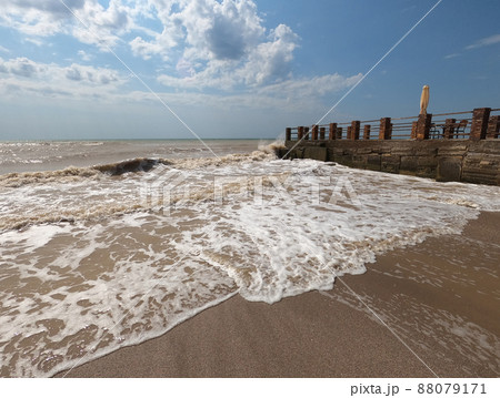 The pier cuts the sea waves off the coast during a stormy sunny day. The pier cuts the sea waves off the coast during a stormy sunny day. 88079171