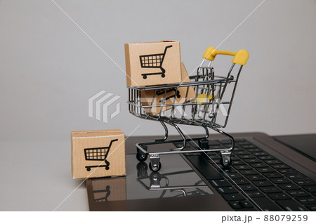 Online sales concept. Trolley with paper boxes on a keyboard close-up Online sales concept. Trolley with paper boxes on a keyboard close-up 88079259
