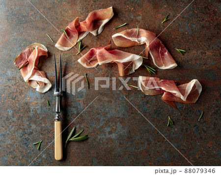 Prosciutto with rosemary on vintage background. Prosciutto with rosemary on vintage background. 88079346