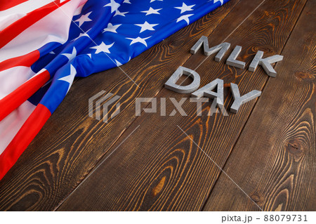 the word MLK day laid with silver metal letters on wooden surface with crumpled USA flag at left side the word MLK day laid with silver metal letters on wooden surface with crumpled USA flag at left side 88079731