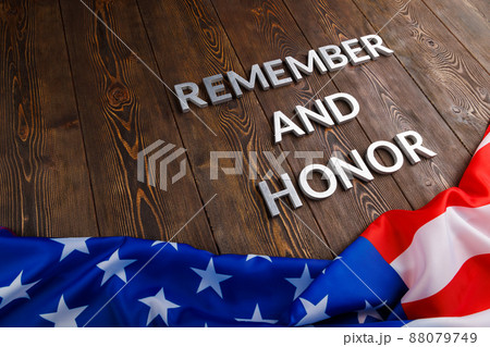 words remember and honor laid with silver metal letters on wooden background with USA flag underneath words remember and honor laid with silver metal letters on wooden background with USA flag underneath 88079749