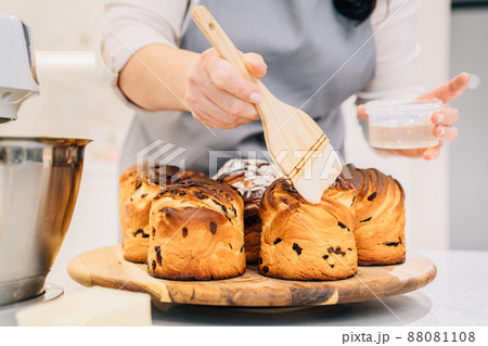 a female cook lubricates with melted butter a Kraffin, easter cake a female cook lubricates with melted butter a Kraffin, easter cake 88081108