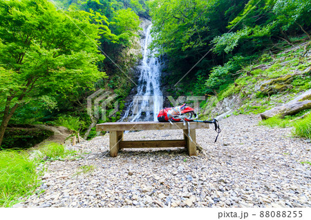 木製のベンチの上に置かれたリュックサックと丸神の滝 木製のベンチの上に置かれたリュックサックと丸神の滝 88088255