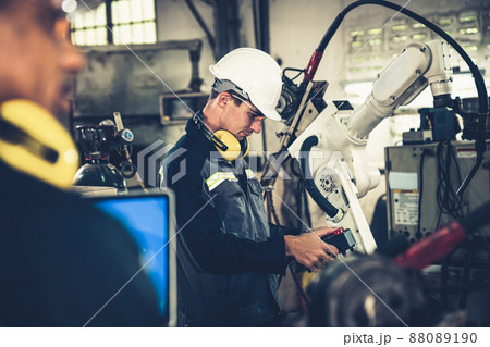 Factory workers working with adept robotic arm in a workshop 88089190