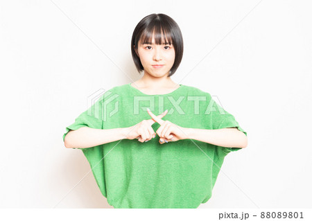 白い壁の前に立ってNGのポーズをする若い女の子 白い壁の前に立ってNGのポーズをする若い女の子 88089801