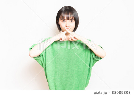 白い壁の前に立ってNGのポーズをする若い女の子 白い壁の前に立ってNGのポーズをする若い女の子 88089803