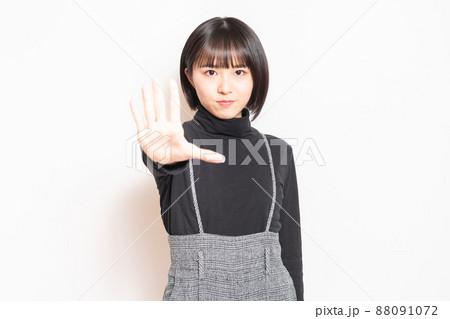 白い背景の前に立ってNGのポーズをする若い女の子 白い背景の前に立ってNGのポーズをする若い女の子 88091072