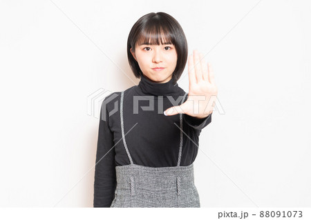 白い背景の前に立ってNGのポーズをする若い女の子 白い背景の前に立ってNGのポーズをする若い女の子 88091073