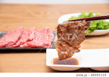 焼肉をタレに付けている様子 88093139